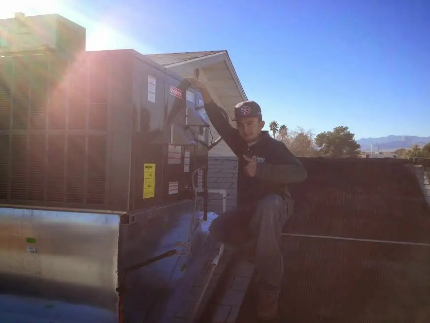 HVAC technician performing Boiler Repair on a rooftop unit in Belton